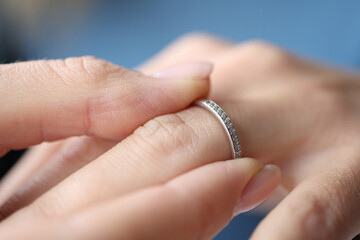 Woman hand putting silver ring on her finger closeup