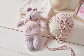 Fototapeta na wymiar Knitted kids clothes and accessories for knitting. Needlework and knitting. Hobbies and creativity. Knit for children. Handmade. Knitted toys rabbit. Handmade toy hare.