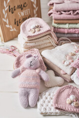Fototapeta na wymiar Knitted kids clothes and accessories for knitting. Needlework and knitting. Hobbies and creativity. Knit for children. Handmade. Knitted toys rabbit. Handmade toy hare.