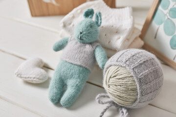 Obraz na płótnie Canvas Knitted kids clothes and accessories for knitting. Needlework and knitting. Hobbies and creativity. Knit for children. Handmade. Knitted toys rabbit. Handmade toy hare.