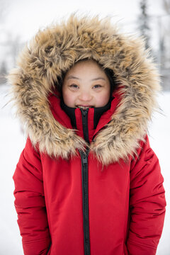 Portrait young woman with Down Syndrome in winter coat with fur hood