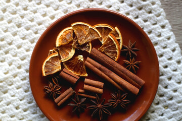 Plate of various winter spices and knitted blanket. Top view.