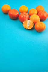 Composition of persimmons and tangerines on a blue background