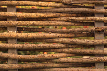 A fence made of wicker branches of a willow tree.