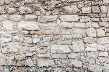 Beige rough stone rock wall