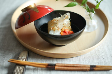 お正月、新年に食べる日本の伝統料理　赤いおわんに入ったお雑煮　飾り切りされたニンジンと大根
