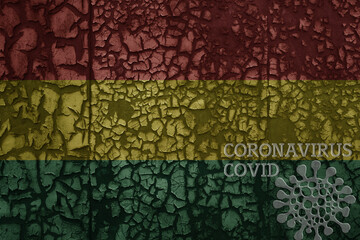 flag of bolivia on a old metal rusty cracked wall with text coronavirus, covid, and virus picture.