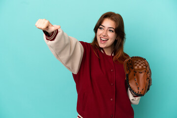 Young redhead woman playing baseball isolated on blue background giving a thumbs up gesture