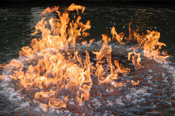 Flames burning on the water surface of an under water gas fire pit
