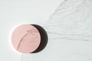 Empty round pastel platform podium on white background with natural light and shadows. Mock up background for cosmetic product presentation. Top view