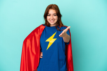 Young caucasian woman isolated on white background in superhero costume and making a deal