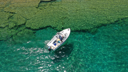 Aerial drone photo of power boat anchored in tropical Caribbean turquoise bay with calm sea