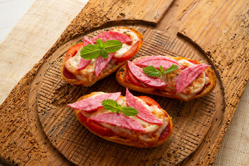 toast with Italian salami, melted cheese and tomato.