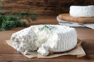 Delicious cottage cheese with dill on wooden table