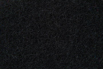 black porous surface of a synthetic sponge for washing dishes and cleaning, close-up. photo with depth of field