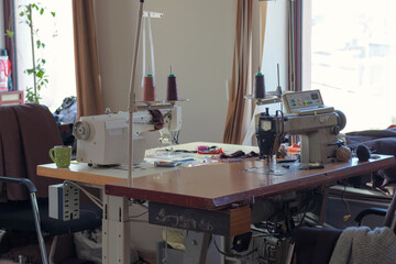Used sewing machine and sewing tools in fashion atelier, selective focus