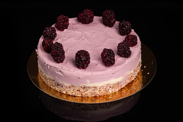 Raw cake made of raspberry and cashew cream on black background