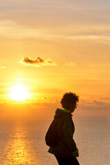 Woman hiking while sunrise over the sea