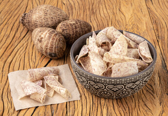 Yam or taro chips in a bowl with raw vegetable over wooden table