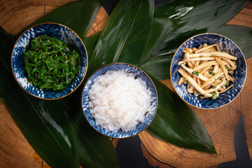 Shirataki rice or noodles, shimeji mushrooms and wakame in bowl on wooden table background....