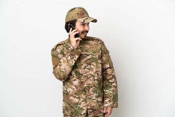 Soldier man isolated on white background keeping a conversation with the mobile phone with someone