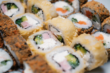 Sushi set with salmon, tuna and cream cheese close-up. Traditional Japanese cuisine side view.