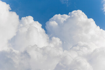 Naklejka na ściany i meble a large white cloud or cloud on a blue sky background. weather and weather conditions. a rain cloud or a storm. meteorology or observation of the weather and nature. rain or evening and a large cloud