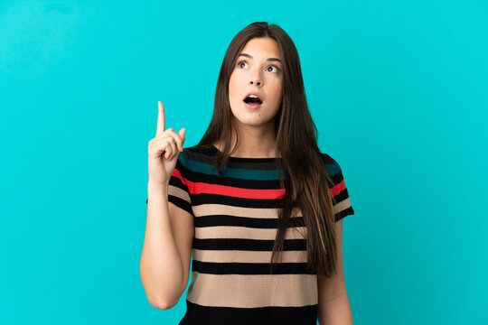 Teenager Brazilian girl over isolated blue background thinking an idea pointing the finger up