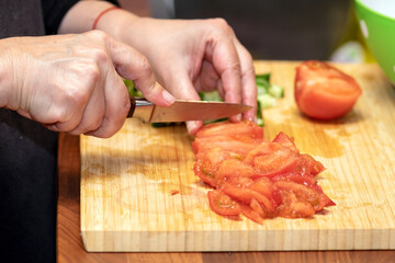 chopping tomato with a kitchen knife