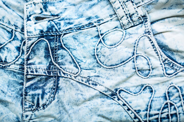 Jeans background. Denim fabric closeup. Textures of clothing fabric with fashion embroidery blue colors. Copy space for text. Fashion and Style.