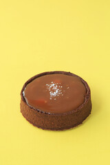 chocolate tartlet with salted caramel on yellow background