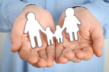 Man holding paper family cutout, closeup view