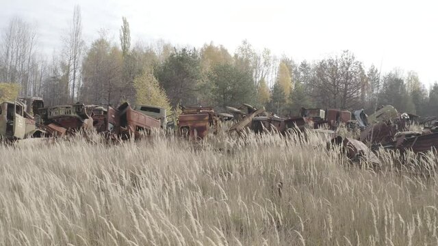 Aerial video. Old abandoned equipment that took part in the elimination of the accident. The village of Rassokha. Chernobyl. Rusty machinery. 