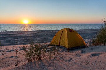 Yellow tent on the sea sand. Tent on the beach. Baltic coast.
