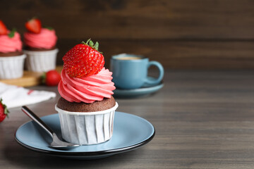 Sweet cupcake with fresh strawberry on wooden table. Space for text