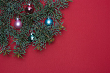 Fototapeta na wymiar Christmas tree branch with Christmas toys on a red background
