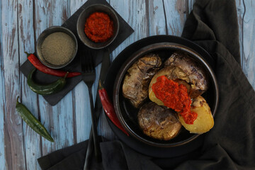 Potatoes with hot salsa sauce on rustic background