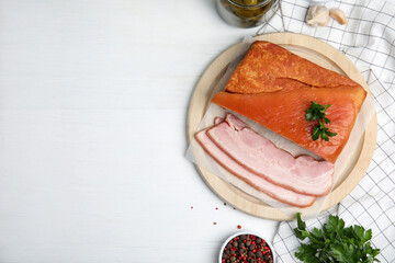 Flat lay composition with delicious smoked bacon on white wooden table, space for text