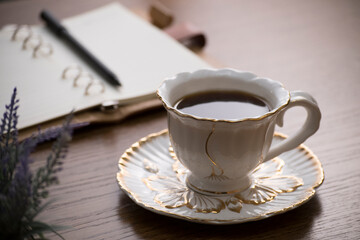 cup of coffee and notebook on table in morning