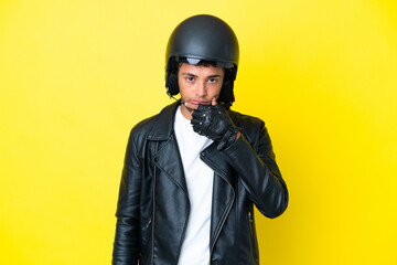 Young Brazilian man with a motorcycle helmet isolated on yellow background thinking