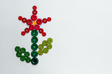 Red, green and yellow buttons folded in the form of a flower on a white background.