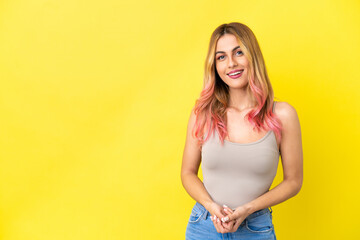 Young woman over isolated yellow background laughing