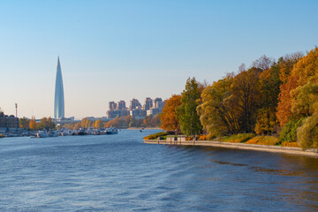 Saint-Petersburg. Russia. View of the city from the autumn park from the embankment of the Lakhtinsky spill. Modern architecture of St. Petersburg. Horizontal frame.