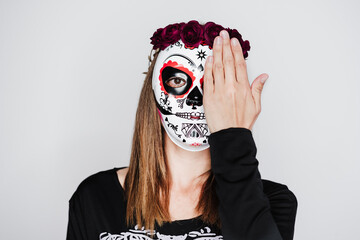 woman wearing mexican face mask during halloween celebration. woman wearing skeleton costume and red roses diadem on head. Halloween party concept