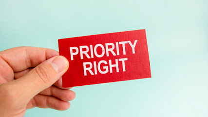 message on the card with text priority right, in hand of businessman.