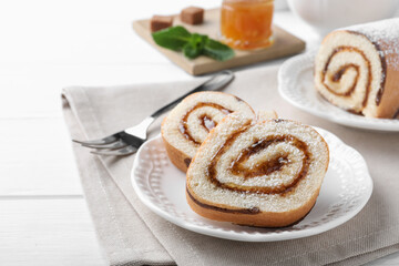 Tasty cake roll with jam on white wooden table. Space for text