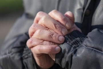 A hand gesture that symbolizes a prayer to God. Old man's hand