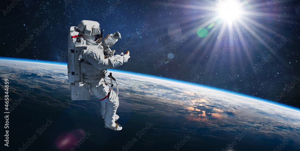 Leinwandbilder astronaut in outer space on orbit of earth planet. sky and clouds. spacewalk with stars. sun light o