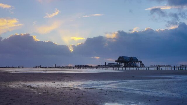 Pfahlbauten bei St. Peter Ording im Sonnenuntergang im Wattenmeer