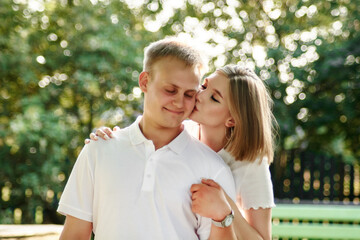 Fototapeta premium A loving guy and a girl are walking in the park. The concept of an outdoor love story.